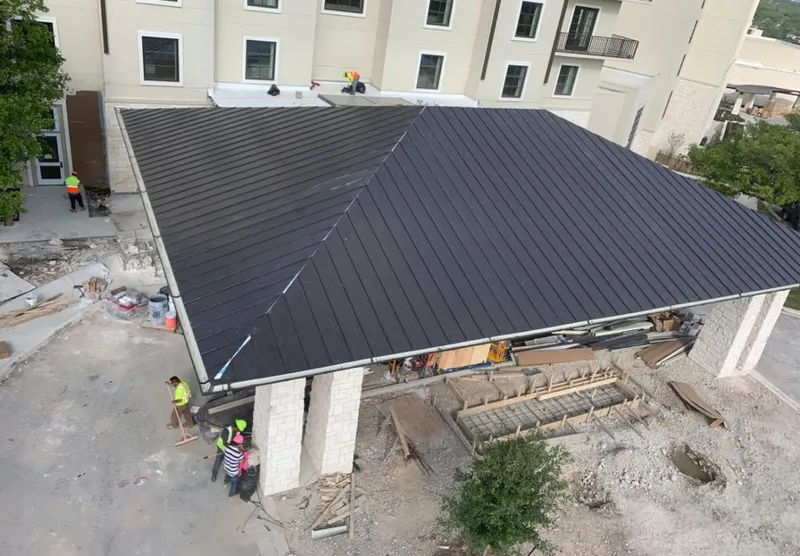 Metal roofing installation team working on a commercial building in Pontotoc
